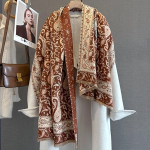 Dettaglio sciarpa paisley color caramello con frange e cappotto di cashmere bianco