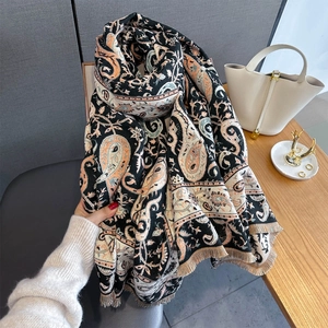 Dettaglio di sciarpa con stampa paisley, bordi con frange e trama a maglia morbida