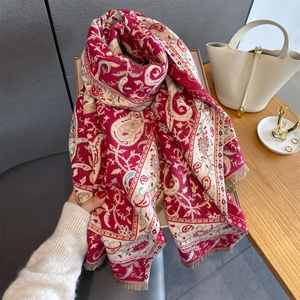 Dettaglio macro della sciarpa in maglia paisley retrò con bordi a frange e crema