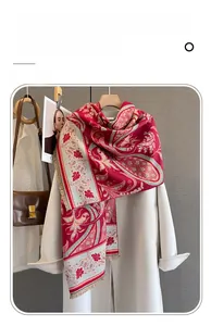 Close-up of imitation cashmere scarf with red paisley pattern and fringe details
