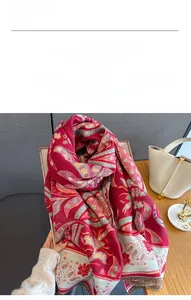Detail of red and grey paisley faux cashmere shawl with tassel trim and thick texture