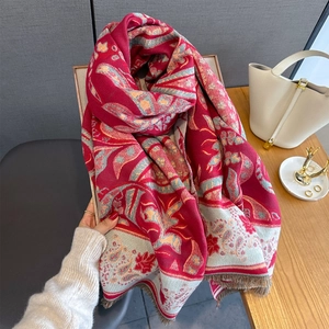 Detailed texture of carmine red paisley cashmere scarf with delicate tassel fringe