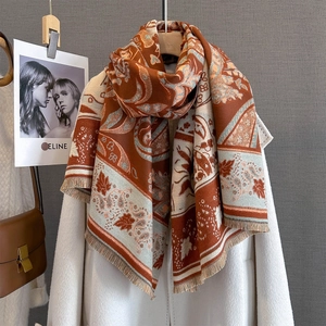 Detail of the rust orange paisley print pattern and tassels on cashmere shawl