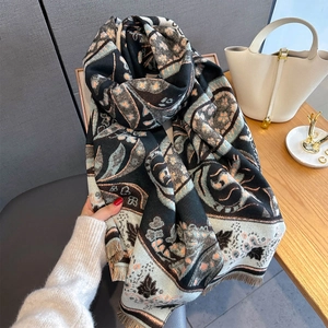 Detail of soft paisley pattern scarf with fringe edges and thick knitted fabric texture