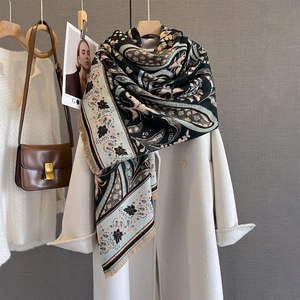 Close-up of paisley pattern and soft fringe on elegant blue and beige cashmere-feel scarf