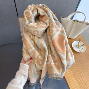 Close-up of geometric jacquard scarf with soft fringe and floral patterns in khaki