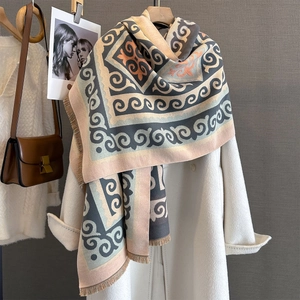 Macro detail of geometric patterned scarf with tassels on cashmere coat and leather bag