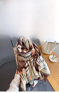 Detailed view of imitation cashmere scarf with geometric patterns and soft fringe edges