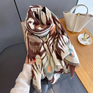 Detailed view of soft cashmere-like scarf featuring geometric tribal patterns and fringe edge