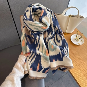 Detailed view of tribal Ikat geometric print shawl with navy and coral soft fringe edges