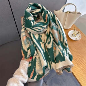 Detailed view of thick knit scarf with geometric zigzag patterns and fringed edges