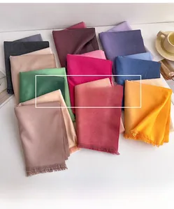 Flat lay of colorful cashmere-feel scarves with soft fringes and diverse vibrant tones