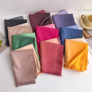 Detail of soft cashmere-like scarves with fringe edges in various vibrant colors