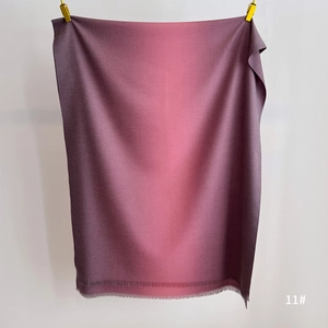Detail of gradient plum to pink cashmere feel scarf with fringe trim and soft texture
