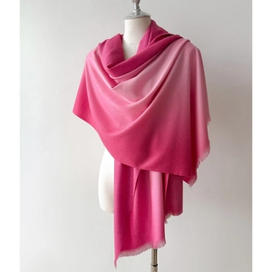 Detail of pink gradient cashmere-like scarf showing smooth texture and fringe edges
