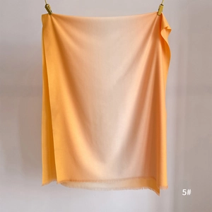 Detail of orange gradient scarf showing cashmere-like texture and soft fringe edges