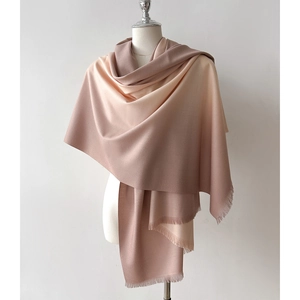 Elegant gradient cashmere-feel scarf with fringes on mannequin, soft beige to brown tones