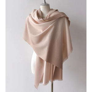 Soft gradient cashmere-feel scarf in apricot pink draped on a white mannequin
