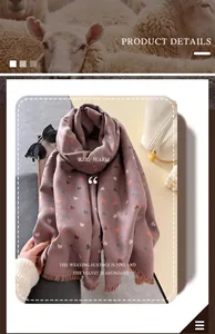Close-up of heart pattern embroidery and soft tassel edges on warm pink cashmere-like scarf