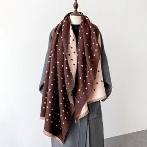 Detail of soft heart-patterned pashmina scarf featuring fringe edges and reversible colors