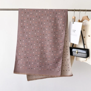 Detailed view of reversible heart pattern scarf with soft tassels and woven texture