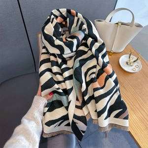 Macro detail of zebra print knit scarf with colorful blocks and soft fringe edges