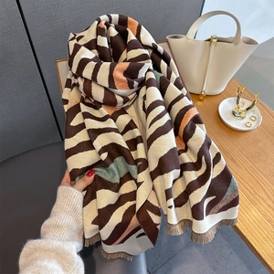 Detail of irregular zebra stripe pattern and soft fringe on this warm cashmere-like scarf