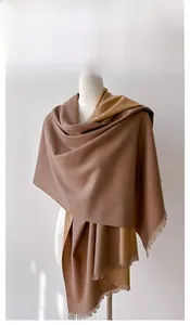 Close-up of double-sided cashmere-like scarf with brown and camel bicolor tassels