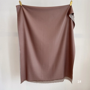 Detail view of double-sided cashmere-like scarf with fringe edges and dual-color design