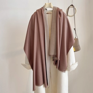 Close-up of double-sided cashmere-style shawl with mocha brown and beige tones and fringe