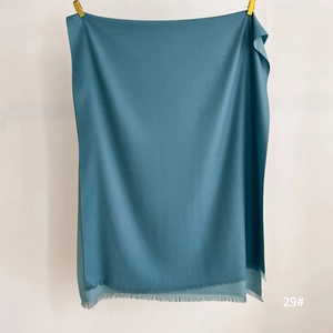 Detailed view of sky blue cashmere-feel shawl with elegant tassel edges and soft texture
