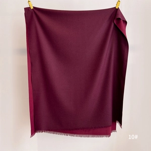 Detailed view of dark burgundy cashmere-feel scarf with elegant matching tassels