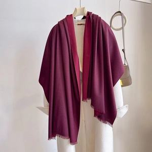 Detail of burgundy faux cashmere scarf with short fringe on white coat