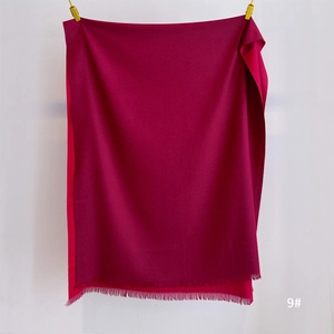 Detail of soft deep rose red pashmina shawl with fine fringe edges and tassel finish