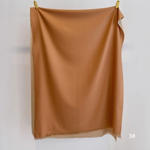 Close-up of brown and beige double-sided cashmere-like scarf with fine tassel fringe detail