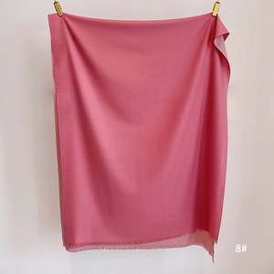 Detail of soft cherry blossom pink scarf featuring fine tassel fringe and silk-like texture