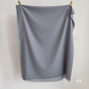 Detail of gray cashmere-like scarf showing soft texture and fine fringe tassels