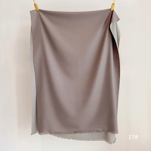 Detail of double-sided cashmere-like scarf in dusty pink and grey with fine fringe tassels