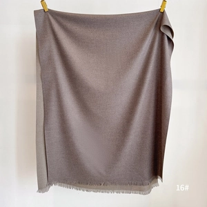 Detail of brown double-sided cashmere-like scarf with neat fringe edges on white background