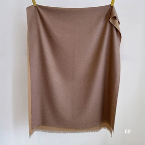 Detail of double-sided cashmere-feel scarf in dark brown and camel with tassels