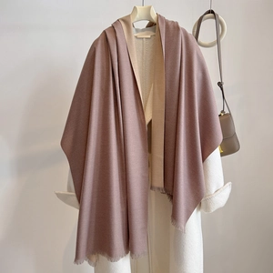 Detail of soft cashmere-like shawl with bicolored pink and beige texture and fringe