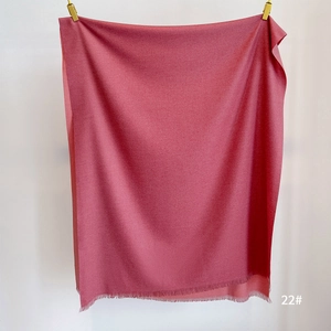 Detail shot of rose red cashmere feel scarf featuring delicate short fringe and soft texture