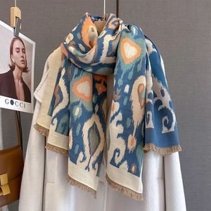 Close-up of geometric pattern scarf with fringe edges and warm multi-color print