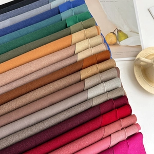 Soft cashmere-feel scarves in various solid colors arranged neatly in a stack