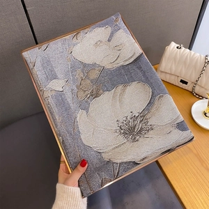 Dettaglio del tessuto jacquard a fiori bianchi con bordo metallico dorato elegante