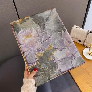 Dettaglio della trama jacquard floreale con loto viola e bordo in metallo oro rosa