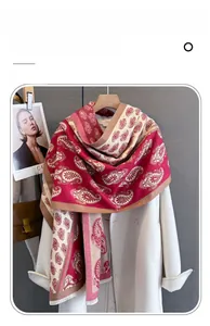 Detailed macro view of imitation cashmere scarf with red paisley print and fine fringe