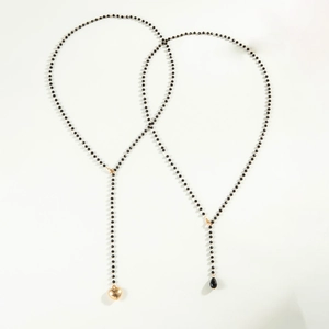 Double-layered beaded necklace with gold heart pendant and black teardrop charm detail