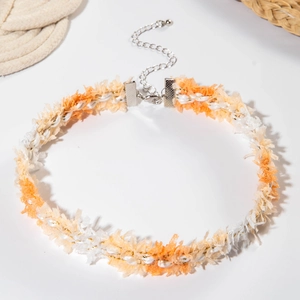 Detailed close-up of orange and white bohemian lace choker with fringe texture