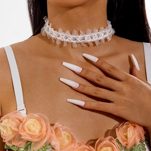 Detail of white lace choker necklace with silver beads in a vintage Maillard style